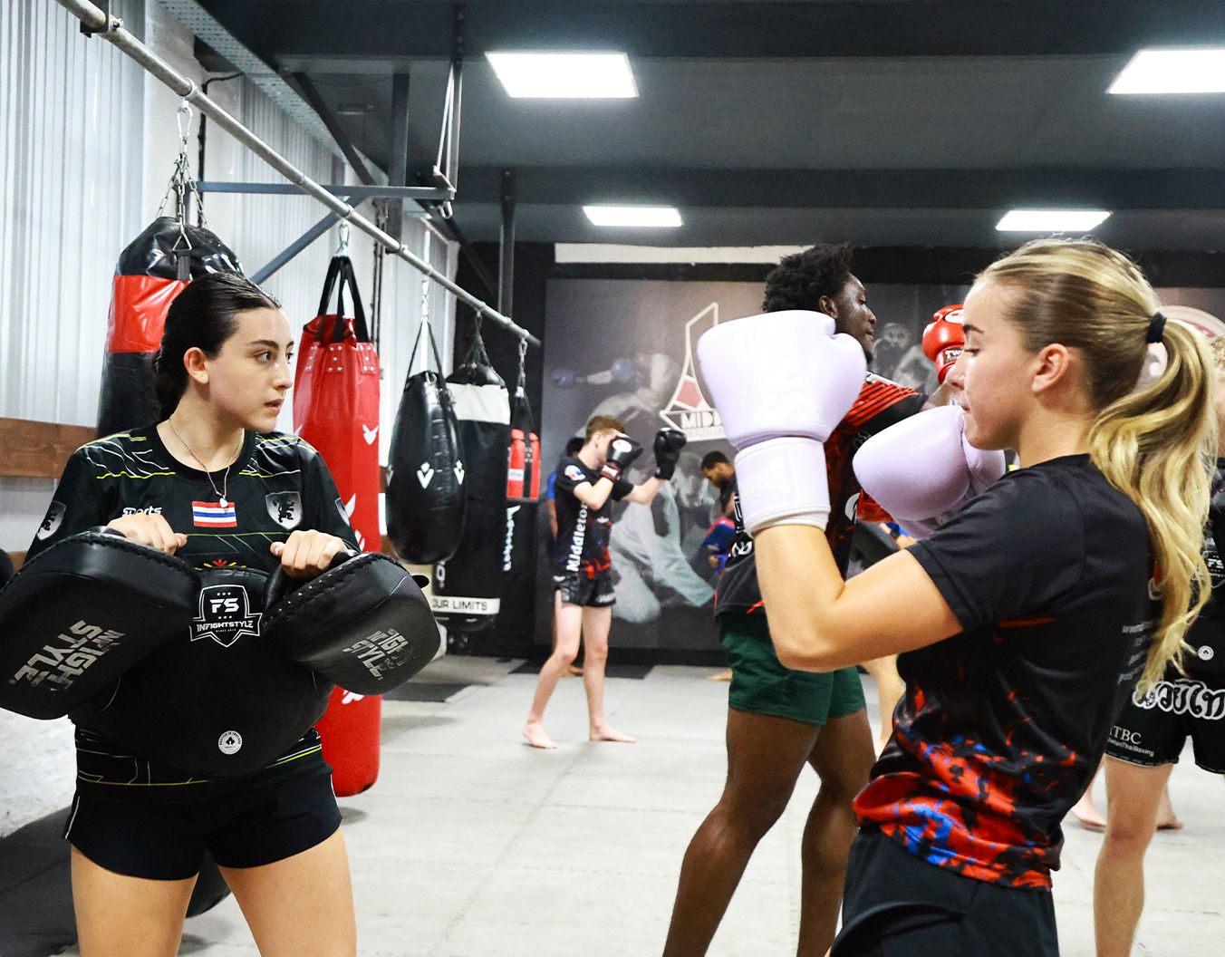2 girls sparring in a boxing gym