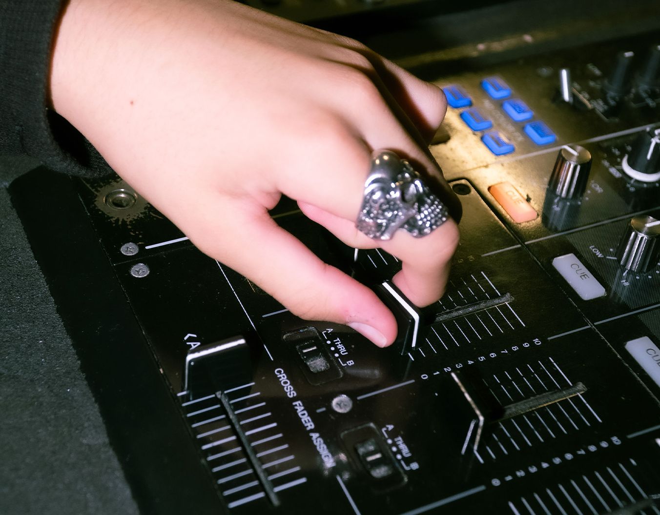 a hand moving a dial on a DJ set