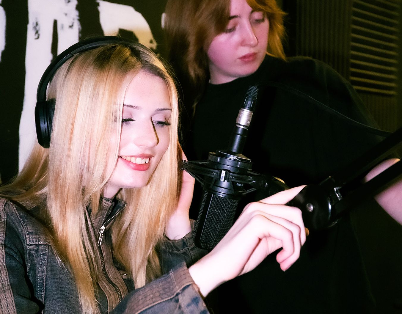 young woman wearing headphones speaking into a microphone
