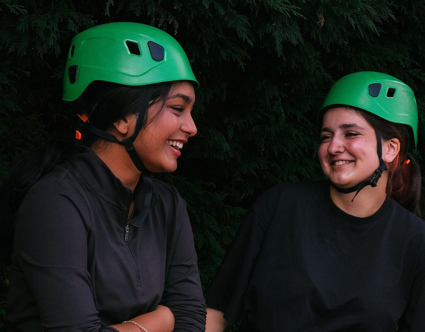 two girls stood laughing together with hard hats