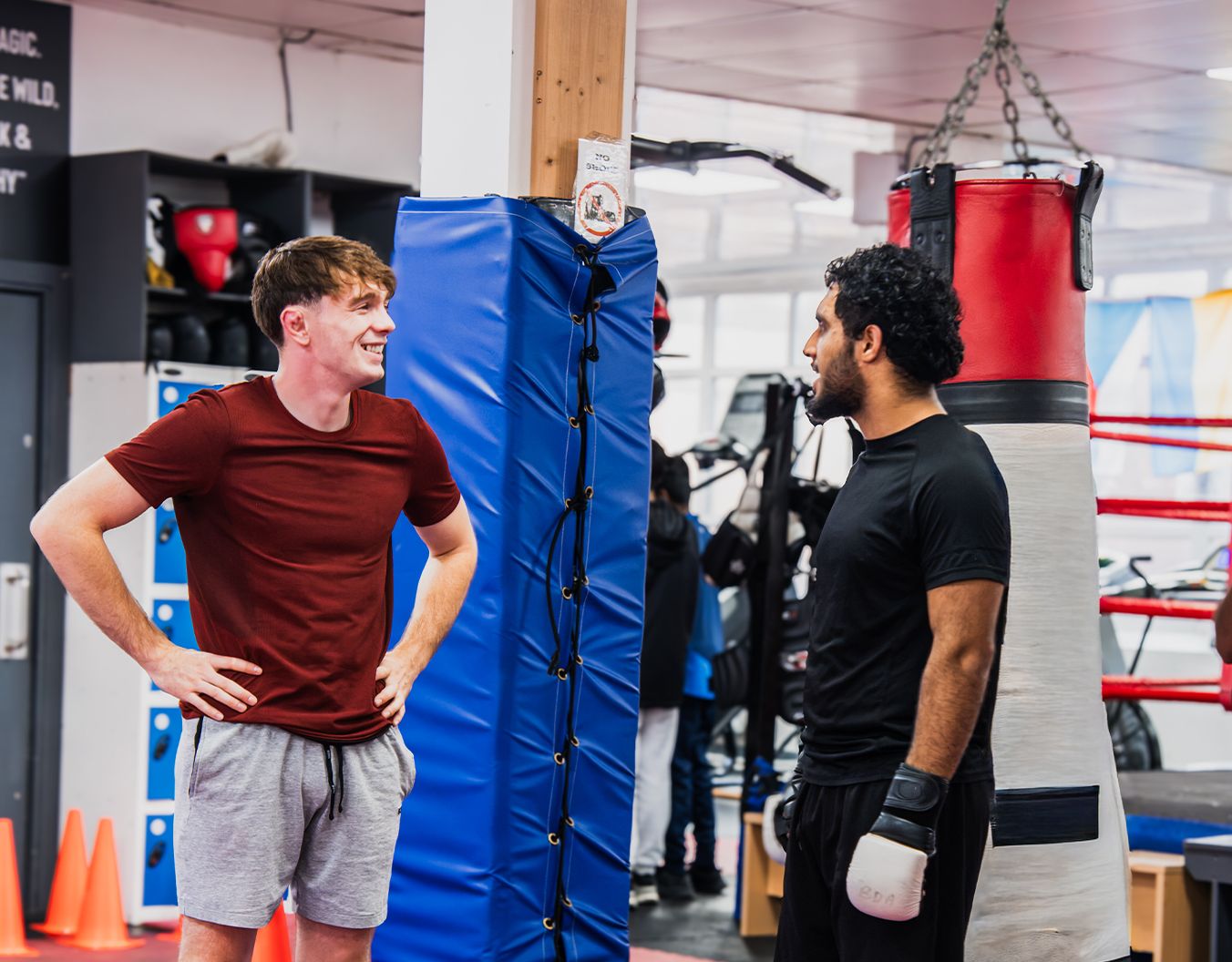 2 people stood in a boxing gym speaking